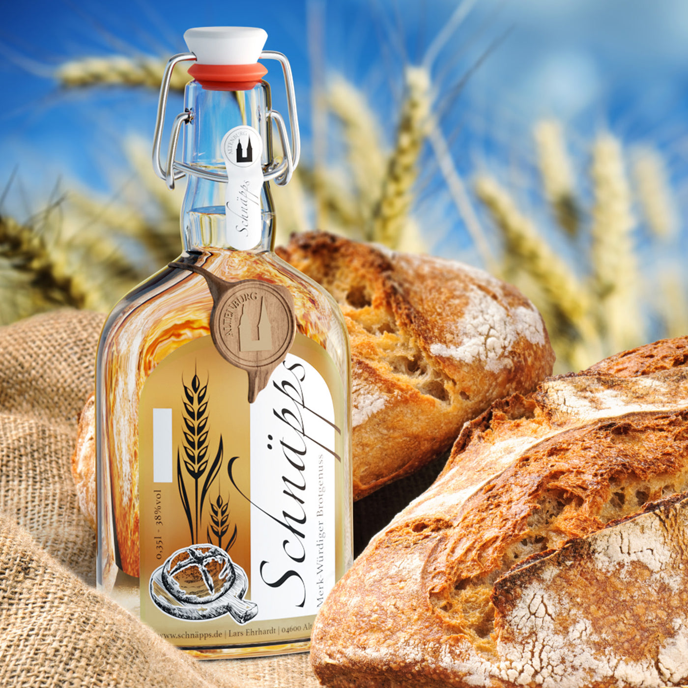 Brotschnaps vor Brotlaiben und Weizen