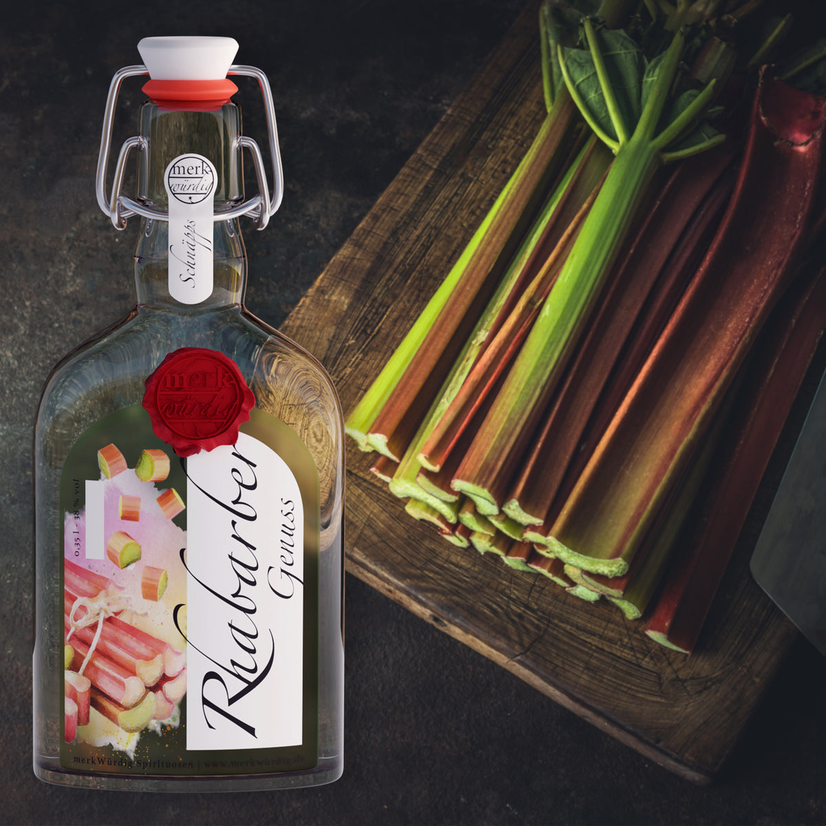 Rhabarbergenuss-Flasche neben frischen Rhabarberstangen auf einem Holzbrett